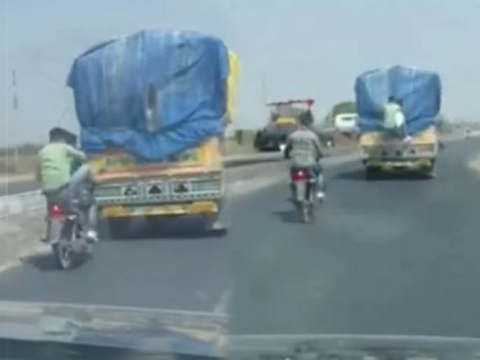 In front of the shocking video came, two boy on a bike stole a sack from a moving truck | धक्कादायक व्हिडिओ आला समोर, दुचाकीवरून आलेल्या दोन मुलांनी चालत्या ट्रकमधून चोरली गोणी In front of the shocking video came, two boy on a bike stole a sack from a moving truck | धक्कादायक व्हिडिओ आला समोर, दुचाकीवरून आलेल्या दोन मुलांनी चालत्या ट्रकमधून चोरली गोणी