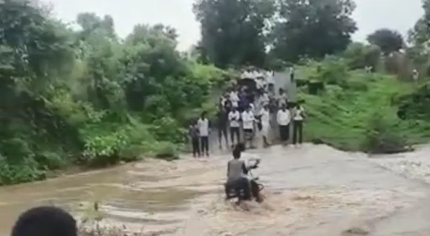 In a nutshell, it was expensive to ride a bike in the flowing water on the bridge | Video : थोडक्यात बचावला जीव, पुलावरील वाहत्या पाण्यात दुचाकी नेणे पडले महागात In a nutshell, it was expensive to ride a bike in the flowing water on the bridge | Video : थोडक्यात बचावला जीव, पुलावरील वाहत्या पाण्यात दुचाकी नेणे पडले महागात
