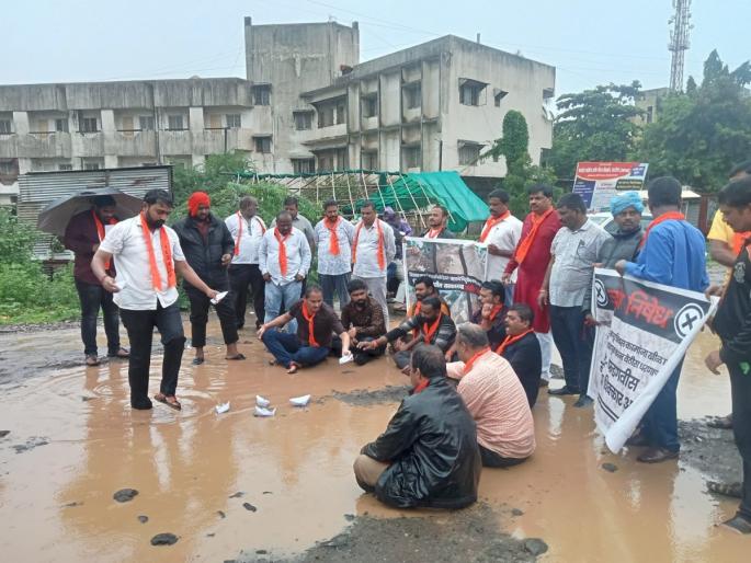 Shiv Sena's agitation from the mud; 'Hodi' movement was done sitting in a puddle | चिखलावरुन उबाठा शिवसेनेचा 'राडा'; डबक्यात बसून केले 'होडी' आंदोलन Shiv Sena's agitation from the mud; 'Hodi' movement was done sitting in a puddle | चिखलावरुन उबाठा शिवसेनेचा 'राडा'; डबक्यात बसून केले 'होडी' आंदोलन