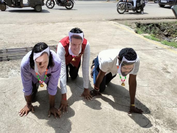 A unique movement by hanging pictures of the Chief Minister, Deputy Chief Minister and tying bells around their necks | चेहऱ्यावर मुख्यमंत्री, उपमुख्यमंत्र्यांचे फोटो, गळ्यात घंटा बांधून अनोखे आंदोलन A unique movement by hanging pictures of the Chief Minister, Deputy Chief Minister and tying bells around their necks | चेहऱ्यावर मुख्यमंत्री, उपमुख्यमंत्र्यांचे फोटो, गळ्यात घंटा बांधून अनोखे आंदोलन