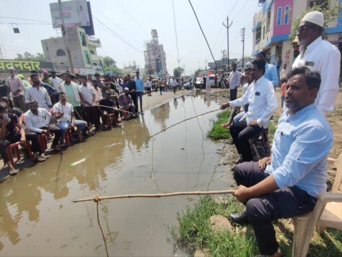 potholes on Dhule-Solapur highway; Fish caught in a pot movement | धुळे- सोलापूर महामार्गावर खड्डे; डबक्यात केले मासे पकडो आंदोलन potholes on Dhule-Solapur highway; Fish caught in a pot movement | धुळे- सोलापूर महामार्गावर खड्डे; डबक्यात केले मासे पकडो आंदोलन