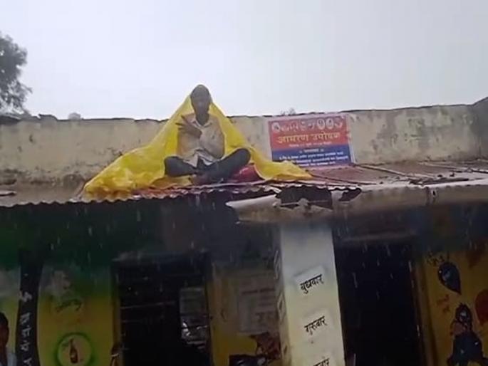 Deplorable state of ZP school; A unique agitation of a Gram Panchayat member sitting on a tin patras roof top in full rain | झेडपी शाळेची दयनीय अवस्था; तुटक्या पत्रावर बसून ग्रामपंचायत सदस्याचे अनोखे आंदोलन Deplorable state of ZP school; A unique agitation of a Gram Panchayat member sitting on a tin patras roof top in full rain | झेडपी शाळेची दयनीय अवस्था; तुटक्या पत्रावर बसून ग्रामपंचायत सदस्याचे अनोखे आंदोलन