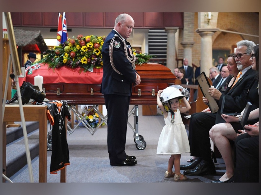 Australia fire : Girl Wears Her Australian Firefighter Dad's Helmet and Refuses to Leave His Side at His Funeral | ऑस्ट्रेलिया : 'या' व्हायरल फोटोची सत्यकथा वाचून तुमचेही डोळे पाणावतील