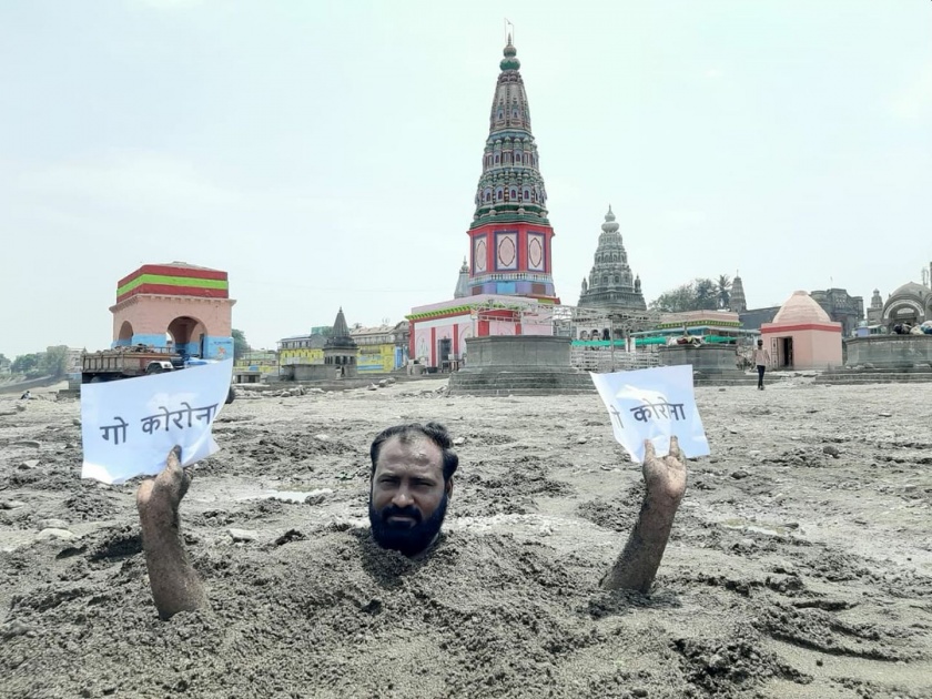 man buries himself in pandharpur prays to lord vitthal to end corona crisis kkg | VIDEO: चंद्रभागेच्या वाळवंटात स्वत:ला गाडून ‘ते’ म्हणताहेत गो कोरोना गो!