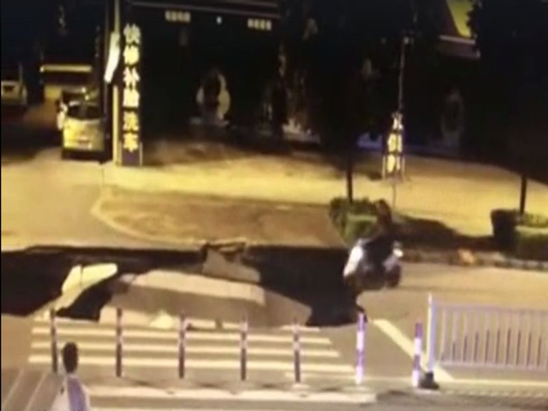 massive sinkhole opens up on road scooter rider falls using mobile | Video: 'फोनवर बिझी होता, स्कूटरसह खड्ड्यात पडला'