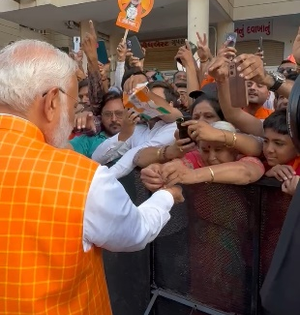 Woman ties rakhi to PM Modi as huge crowd gathers outside polling both in Ahmedabad | Woman ties rakhi to PM Modi as huge crowd gathers outside polling both in Ahmedabad