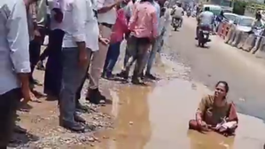 Woman sits in pothole to flag poor condition of roads in Hyderabad | Woman sits in pothole to flag poor condition of roads in Hyderabad