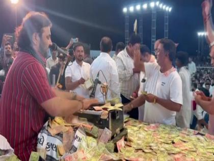 Gujarati folk singer showered with cash during bhajan programme | Gujarati folk singer showered with cash during bhajan programme
