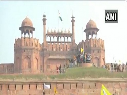 Anti-farm laws protestors wave flags from ramparts of Red Fort in Delhi | Anti-farm laws protestors wave flags from ramparts of Red Fort in Delhi