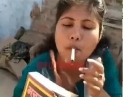 Woman sets Manusmriti on fire, lights cigarette with it | Woman sets Manusmriti on fire, lights cigarette with it