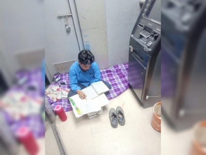 Security guard found studying sitting on ground near ATM machine; pic goes viral | Security guard found studying sitting on ground near ATM machine; pic goes viral