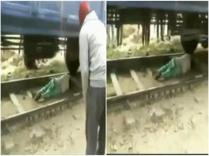 Watch Video! Woman lies down on railway track after she gets trapped under moving train | Watch Video! Woman lies down on railway track after she gets trapped under moving train