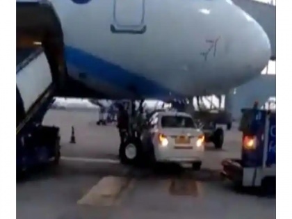 Car stops under nose area of Indigo aircraft parked at Delhi airport | Car stops under nose area of Indigo aircraft parked at Delhi airport