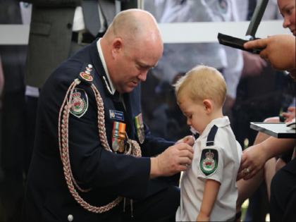 Australia fires: Son of firefighter Geoffrey Keaton awarded medal at funeral | आग बुझाते हुए शहीद पिता के मासूम बेटे ने लिया बहादुरी मेडल, इंटरनेट पर वायरल हुई दिल को छू जाने वाली तस्वीर