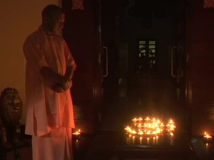 Lucknow: UP CM Yogi Adityanath lights earthen lamps to form an 'Om', at his residence. PM Modi had appealed to the nation to switch off all lights of houses today at 9 PM for 9 minutes, and just light a candle, 'diya', or flashlight, to mark India's fight | देश भर में दीप जलाकर दिया गया कोरोना के खिलाफ एकजुटता का संदेश, सीएम योगी ने मिट्टी के दीपक से 'ओम' बनाए