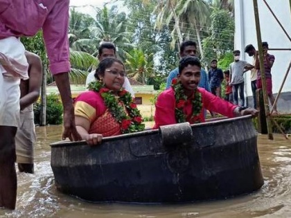 Monsoon Wedding Bride groom in Kerala reach flooded hall in cooking vessel marriage | केरल में भारी बारिश, बाढ़ के बीच खाना बनाने वाले बर्तन में बैठ शादी करने पहुंचे दुल्हा-दुल्हन, देखें वीडियो