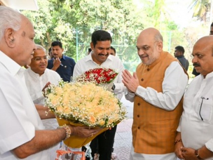 Bengaluru Amit Shah insists receiving bouquet BS Yediyurappa's son Vijayendra interesting turn of events Karnataka see video | अमित शाह कार से उतरे और येदियुरप्पा के छोटे बेटे विजयेंद्र से गुलदस्ता लिया, पीठ थपथपाई और तस्वीरें भी खिंचवाईं, देखें वीडियो