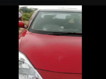 Greater Noida 20 rounds fired at a car parked in the parking lot police seen collecting empty shells know what is the matter | ग्रेटर नोएडा: पार्किंग में खड़ी कार पर 20 राउंड फायरिंग, खाली खोके जुटाती दिखी पुलिस, जानें क्या है मामला