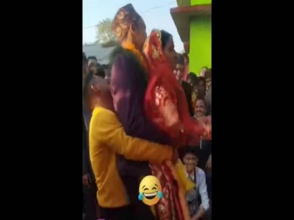 bride and groom fall down when lifted together for ritual watch viral video | शादी की रस्म के दौरान जमीन पर गिरे दूल्हा-दुल्हन, वायरल वीडियो रोक नहीं पाएंगे हंसी