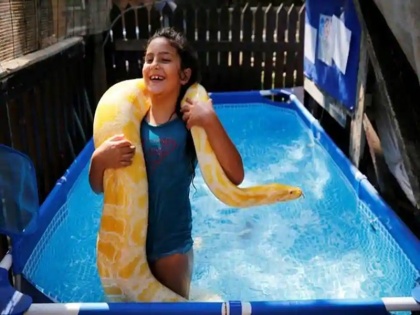 Trending news: 8-year-old girl Inbar with 11-foot long pet python | Video: 11 फीट लंबे अजगर के साथ रहती है लड़की, स्वीमिंग पुल में बिताती है वक्त