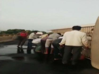 Karnataka: Locals collect fuel from toppled tanker in Kalaburagi's Jevargi | कर्नाटकः सड़क पर पलटा टैंकर, पेट्रोल लूट ले गए स्‍थानीय लोग