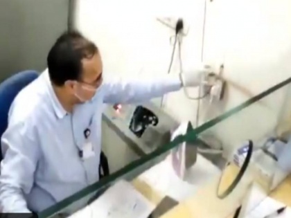 Gujarat banker uses steam iron fight with coronavirus Anand Mahindra share video | बैंक में कोरोना वायरस को 'मारने' के लिए कैशीयर कर रहा है स्टीम आयरन का इस्तेमाल! आनंद महिंद्रा ने शेयर किया वीडियो