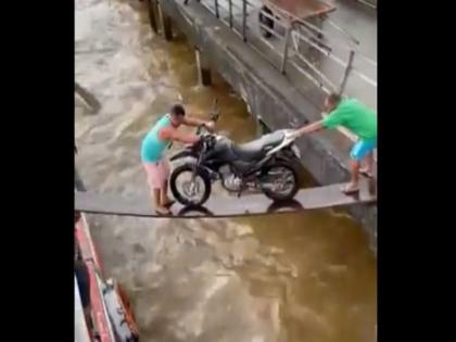 loading bike on the boat with the help of wooden sticks then what happened in this funny video | लकड़ी के फट्टे के सहारे बाइक पार कराने की कोशिश कर रहे थे लोग, अचानक बीच में हुआ कुछ ऐसा, वीडियो वायरल