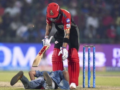 IPL 2018: Fan Breaches Security to touch Virat Kohli feet and click selfie | IPL 2018: सुरक्षा घेरा तोड़ मैदान में जा पहुंचा फैन, छुए विराट कोहली के पैर फिर ली सेल्फी